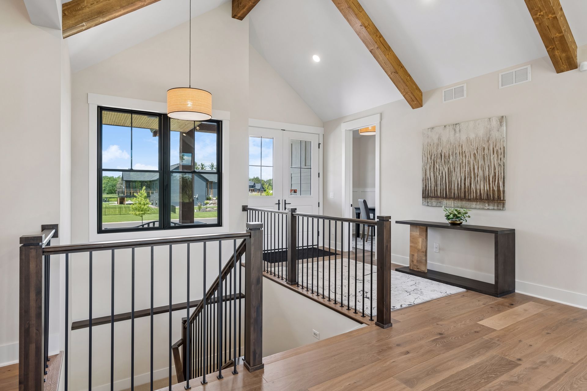 Open foyer with staircase railing and modern entry design